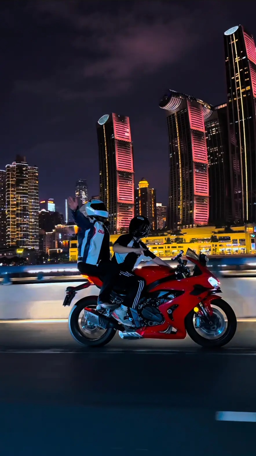 Red sportbike ride past the Raffles towers